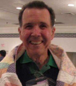 This gentleman is smiling because he's wrapped in a Polly Ellerbe quilt.